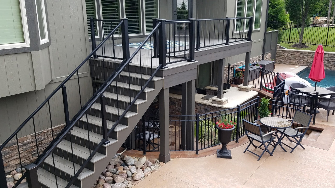 Westbury Railing Vertical Cable panel exterior handrail system on pool deck with vertical stair cable and crossover stair rail in black texture with stainless vertically hung cable wires