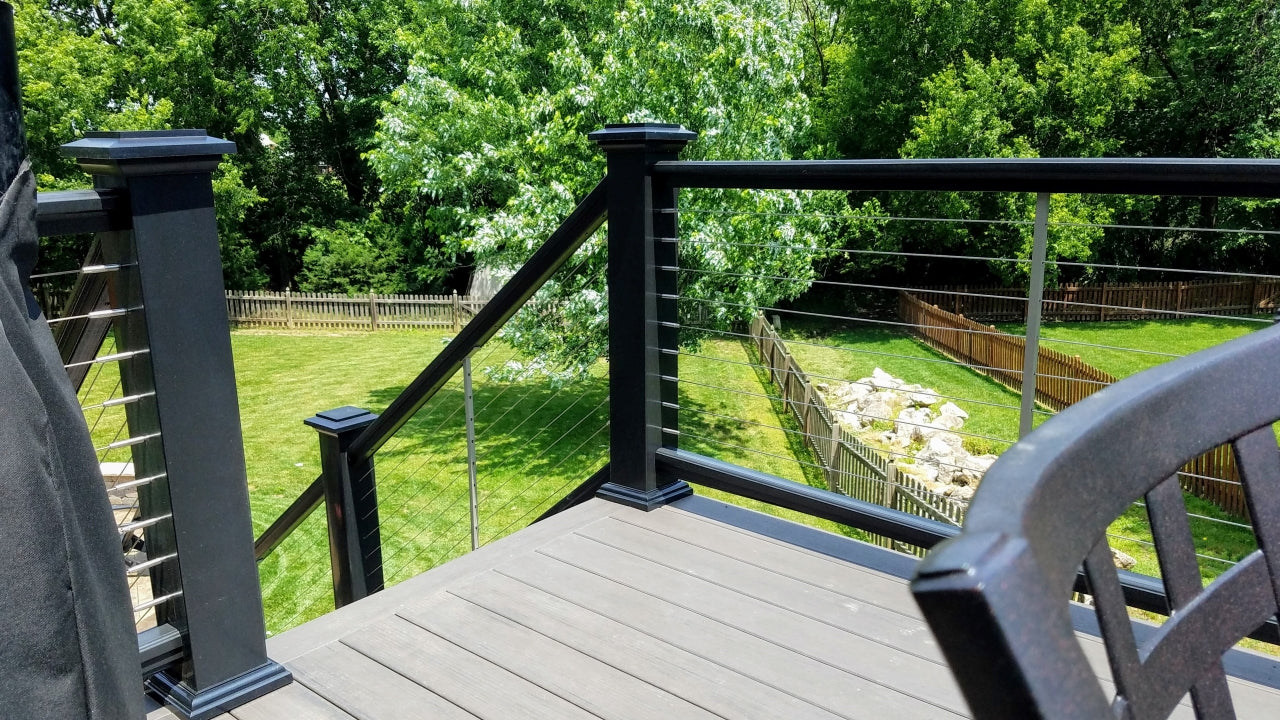 Composite Premier Rail a TimberTech Railing System with Cable infill, and Lighted Island Post Caps in Black colored railing, post sleeves, post caps, and post flairs 