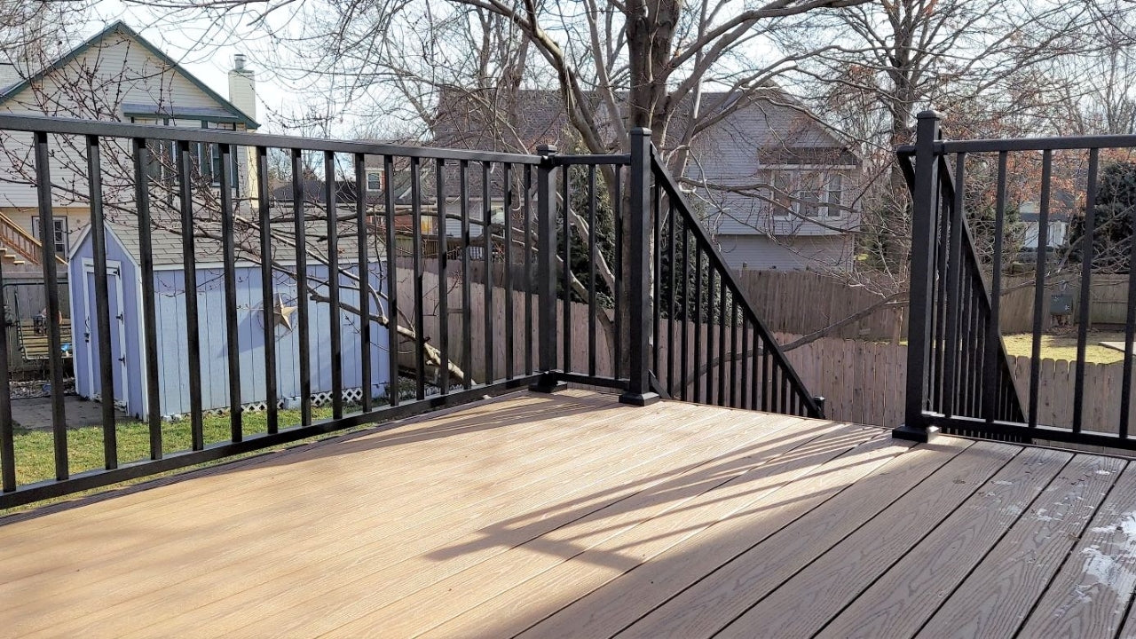 C10 Tuscany Railing Black Fine Texture level railing on top of a composite deck which transitions to stair railing with posts, all alluminum handrail