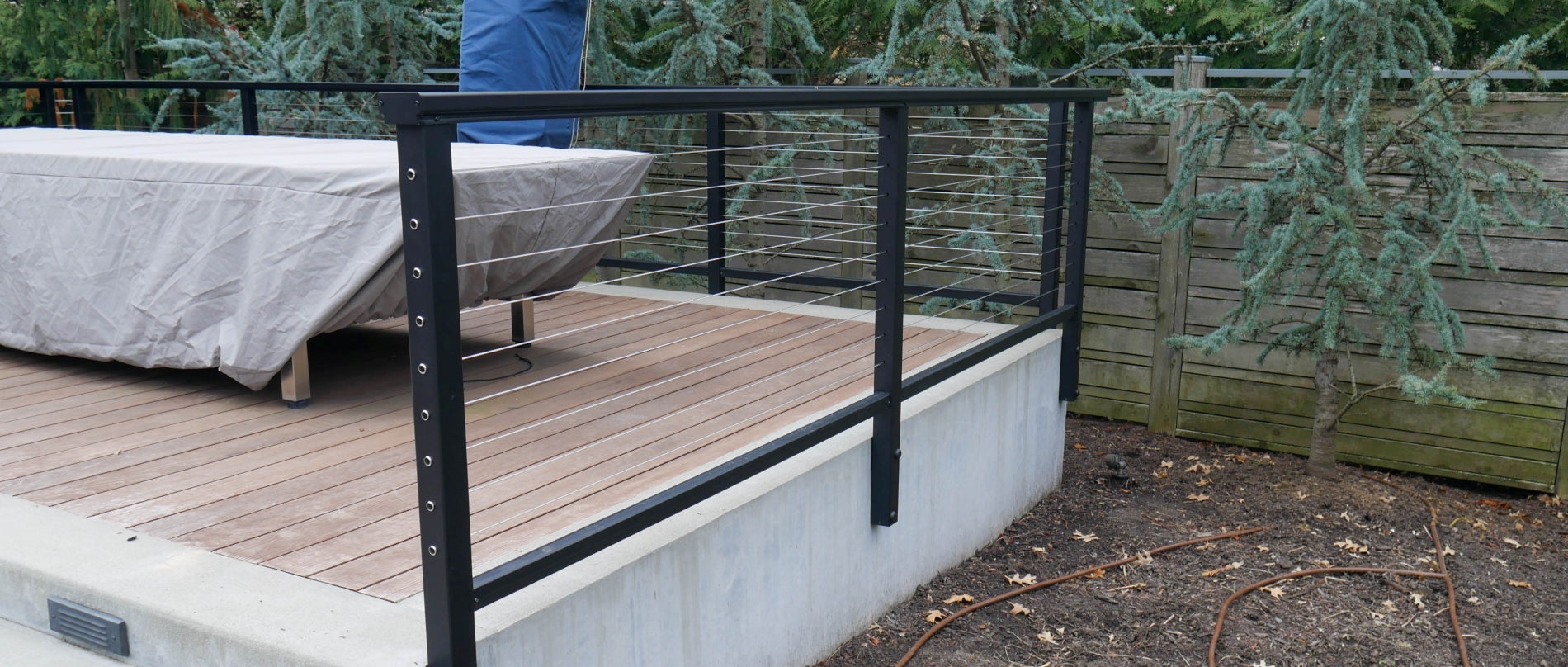 Feeney DesignRail Custom Fascia Mount Posts with cable wire infill and bottom rail with series 200 2x4 aluminum top rail profile.