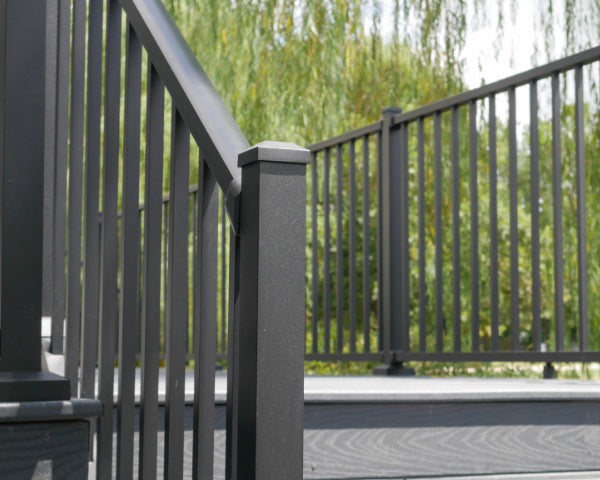 Front stair rail westbury tuscany C10 top end aluminum guardrail railing at the bottom of a set of steps looking up showing the top of the deck with a cascade of railing awesomness