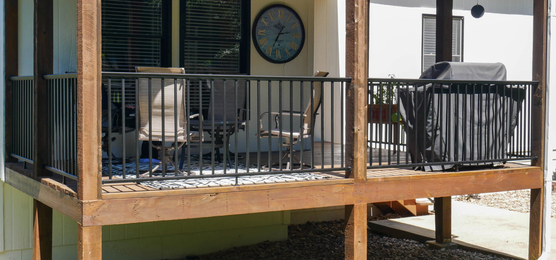 DekPro Prestige black handrail in between pre-existing cedar posts on a covered back deck.