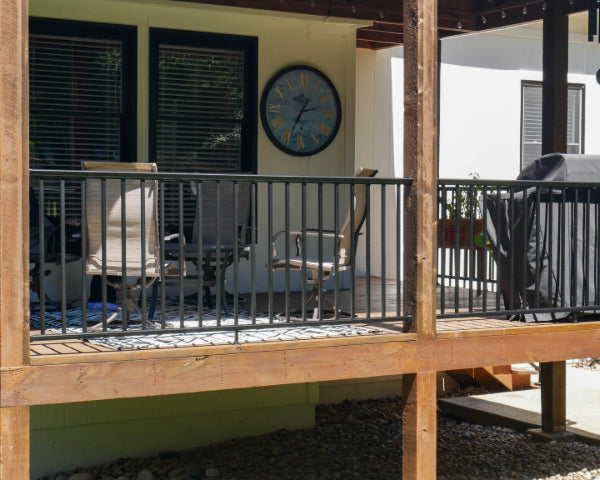 DekPro Prestige black handrail in between pre-existing cedar posts on a covered back deck.