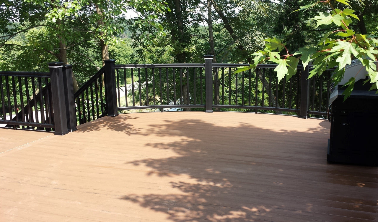 Curved Front Railing, Composite Curved Rail in RadianceRail Composite Railing with TimberTech Terrain Decking a capped composite brown decking, also has lighted light rings or glow rings in the post cap, lighted by led