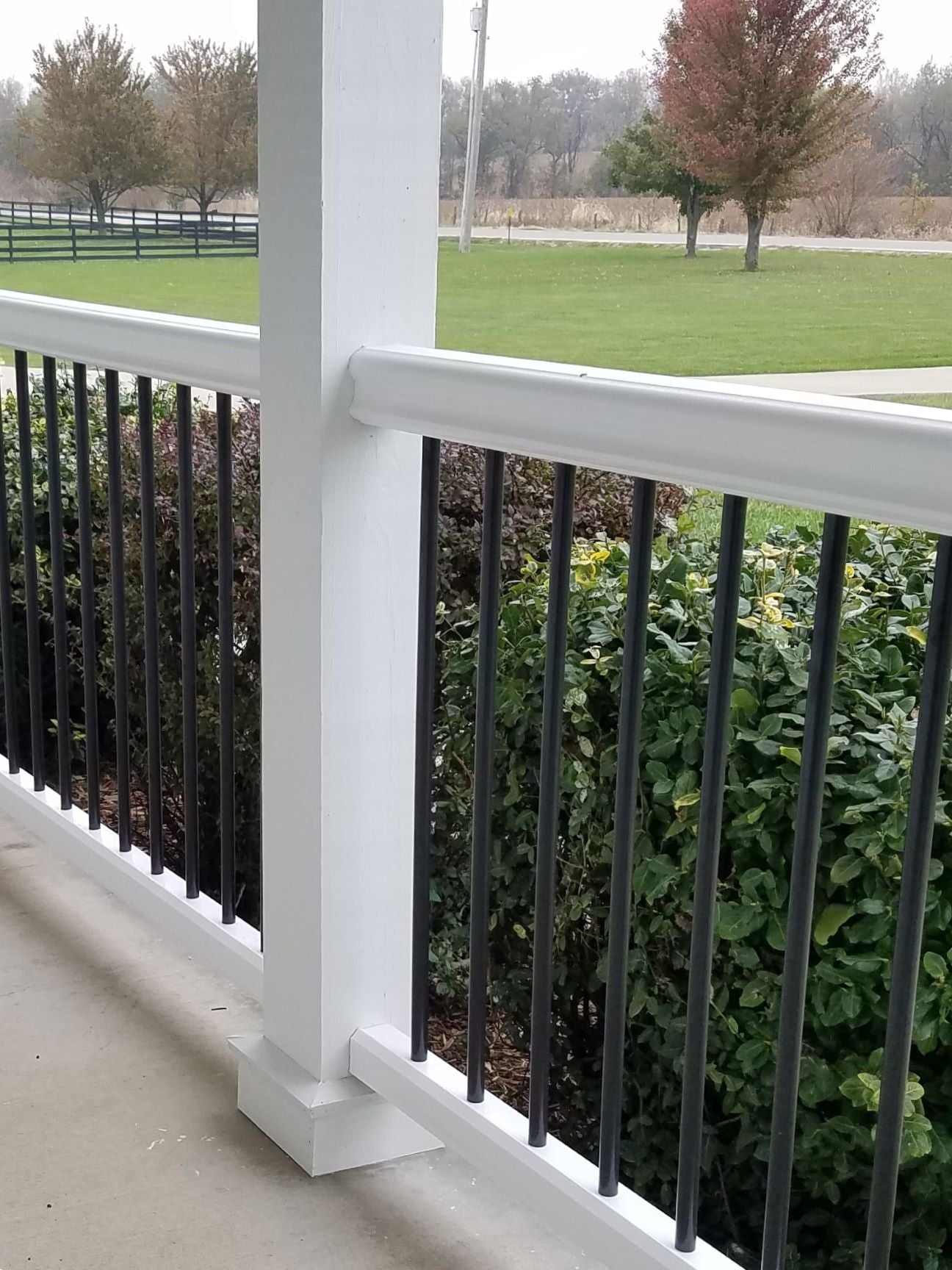 TimberTech Azek Premier Railing Composite Cap Rail with Aluminum Round Balusters Rail and posts are white and infill balusters are black