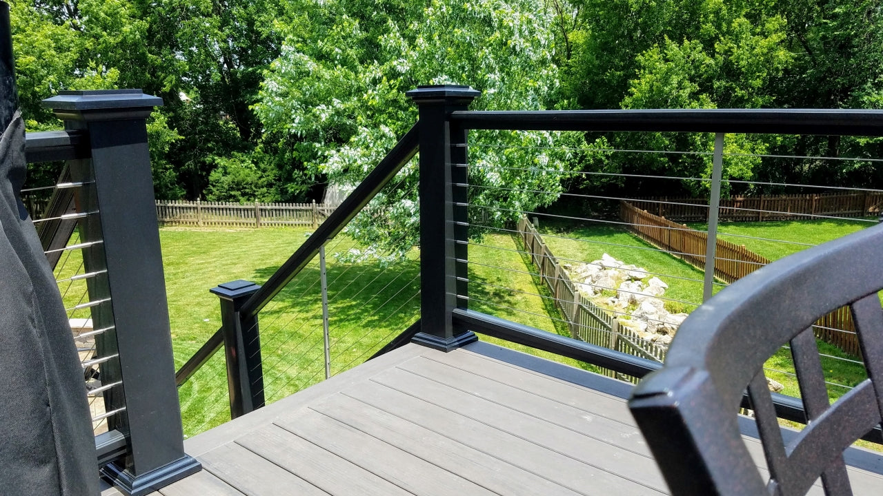 Composite Premier Rail a TimberTech Railing System with Cable infill, and Lighted Island Post Caps in Black colored railing, post sleeves, post caps, and post flairs 