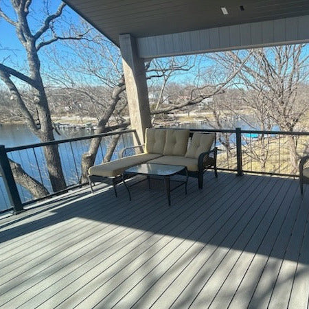 KeyLink Black Vertical Wire Chesapeake Drink Rail on an Outdoor deck with furniture overlooking a body of water
