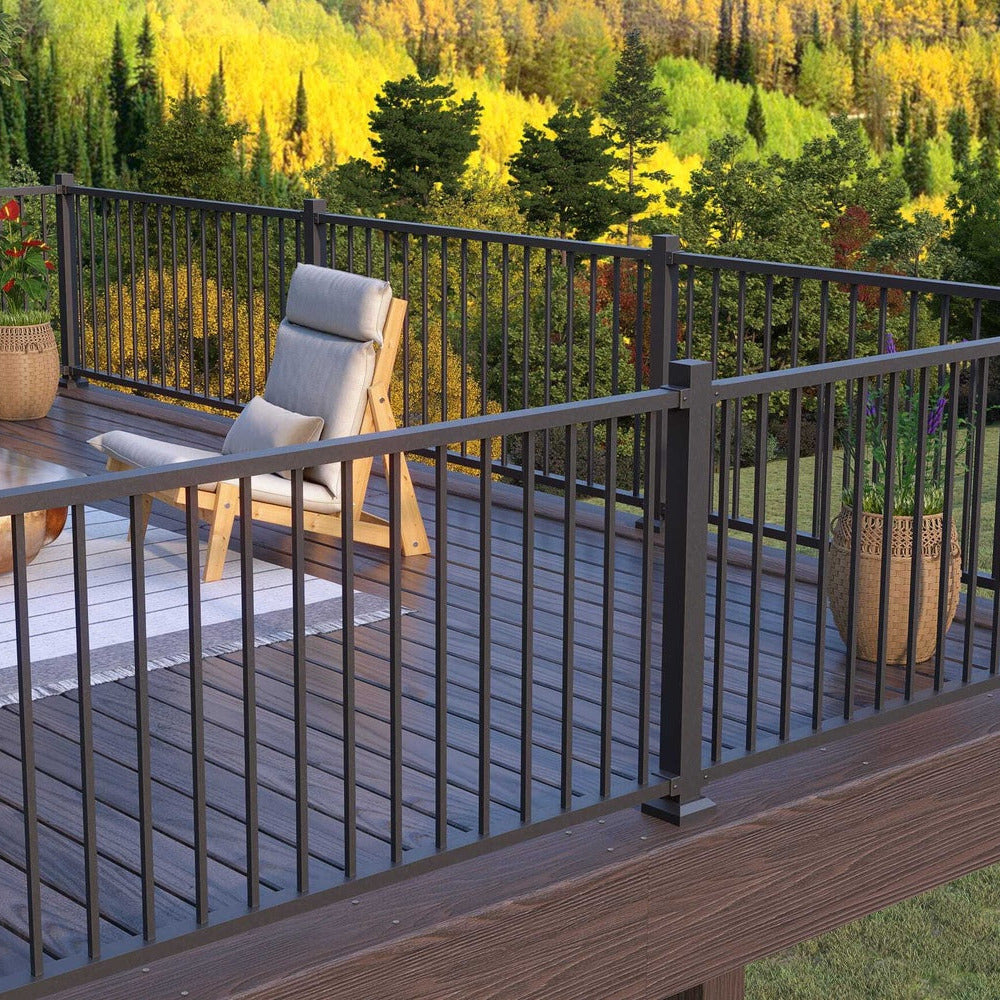 KeyLink Discovery Series Outdoor deck railing with furniture on a composite deck by greenery