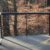 Feeney 250 Modern Drink Rail in black metal railings overlooking a dense forest of bare trees and autumn foliage.