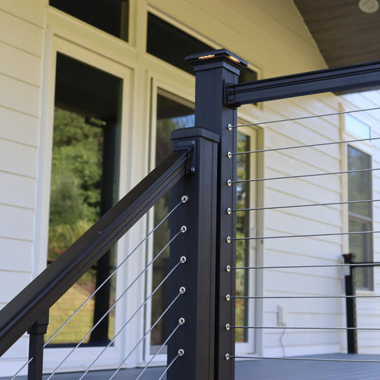 Black metal railing with cable design on a deck