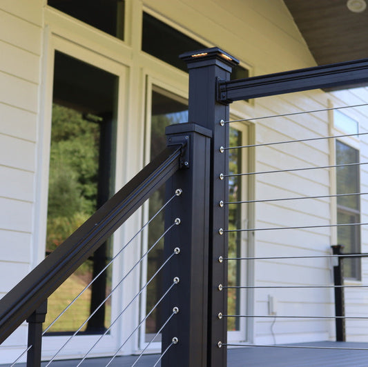 Black metal railing with cable design on a deck