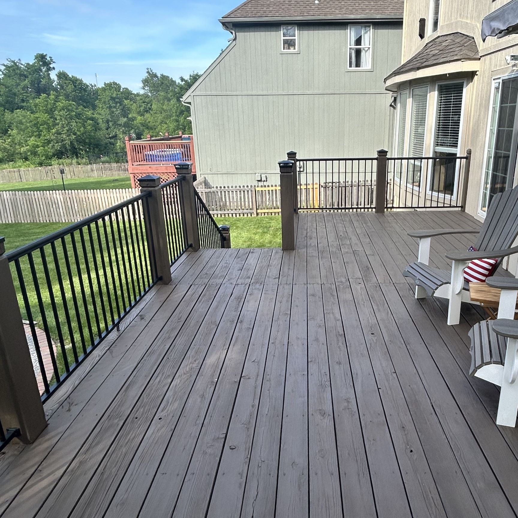 Outlook Handrail between wooden posts on a suburban back yard. Keylink outlook has a thin profile and looks great in contrast with oversized posts as seen in the photo. 6x6 wood posts are easily attached to with outlook brackets, included in rail kits.