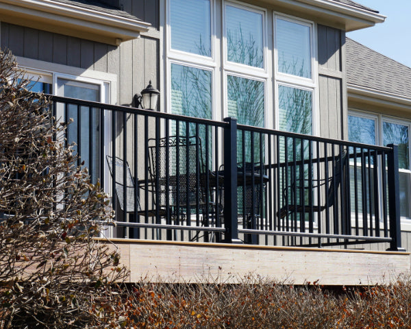 Dekpro Prestige Black handrail on sunny back deck with metal chairs and a table.