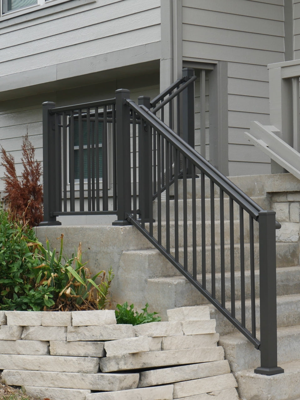 Bronze Front Porch Patio Step Railing with Graspable round continuous handrail on the front of the house aluminum handrail with base mount posts mounted to concrete or cement steps with concrete lags