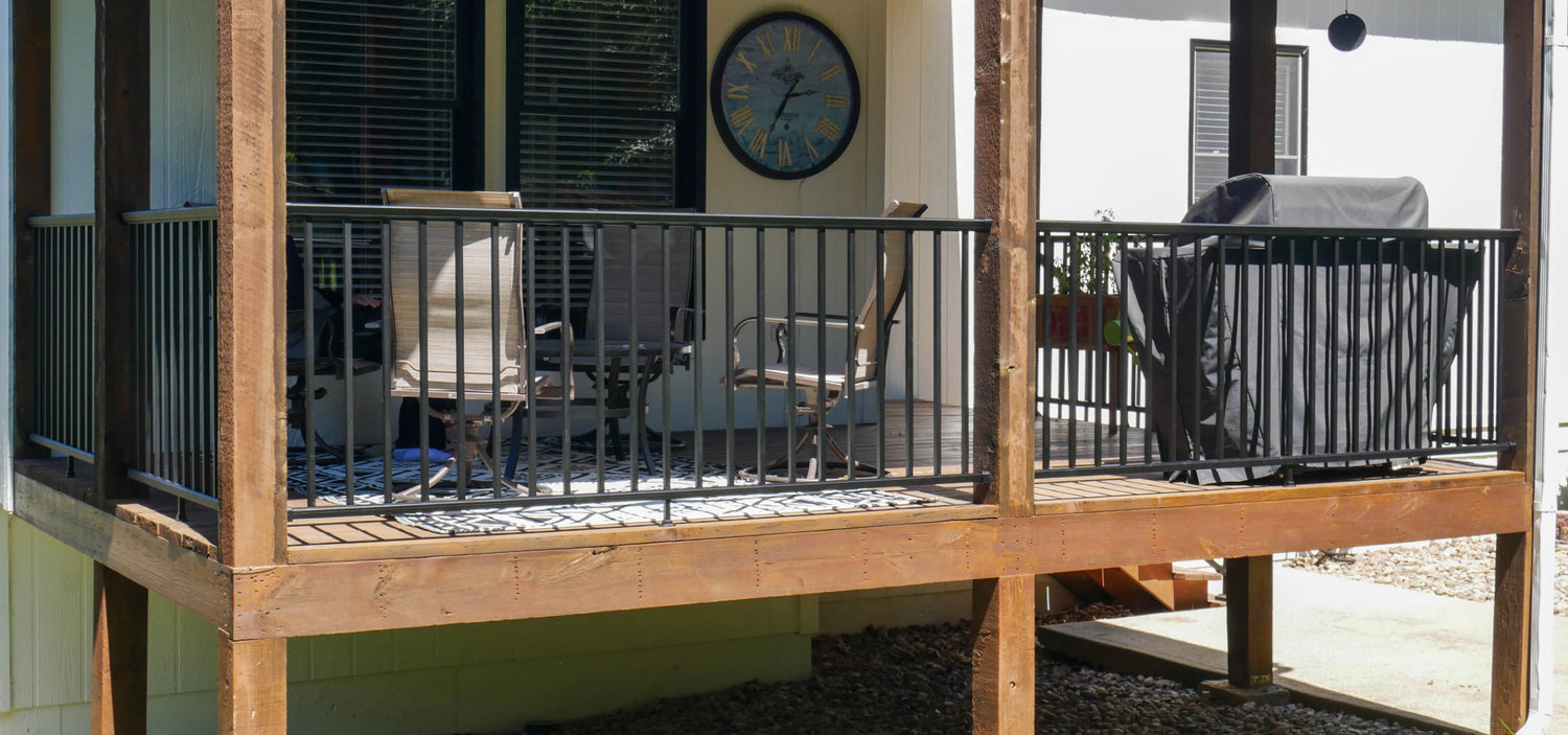 DekPro Prestige black handrail in between pre-existing cedar posts on a covered back deck. 