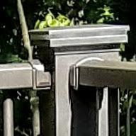 A Corner Post with two Wall mount brackets on adjacent sides in Bronze Fine texture with a Lighted Cap 4" post kit