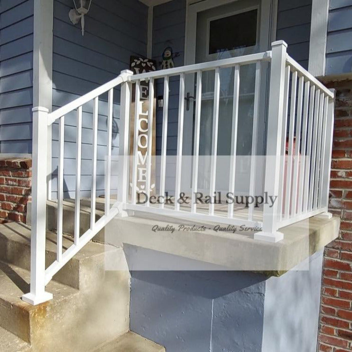 White Westbury Tuscany C10 Railing - stairs are seen on the left side of the photo with a taller post at the base of the steps, and level railing can be seen on the right side in an l-shape 
