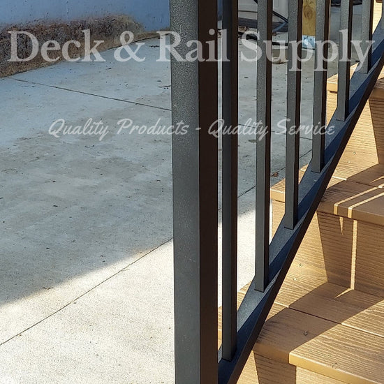 47 inch black texture stair post on composite deck stair tread at the bottom of the stair way with handrail attached  to side, not included are handrails and railing.