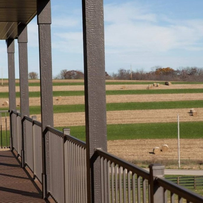 Key Link Bronze Aluminum Outlook Railing infront of a hay field green and tan landscape. railing is attached installed to column posts as well as aluminum keylink posts